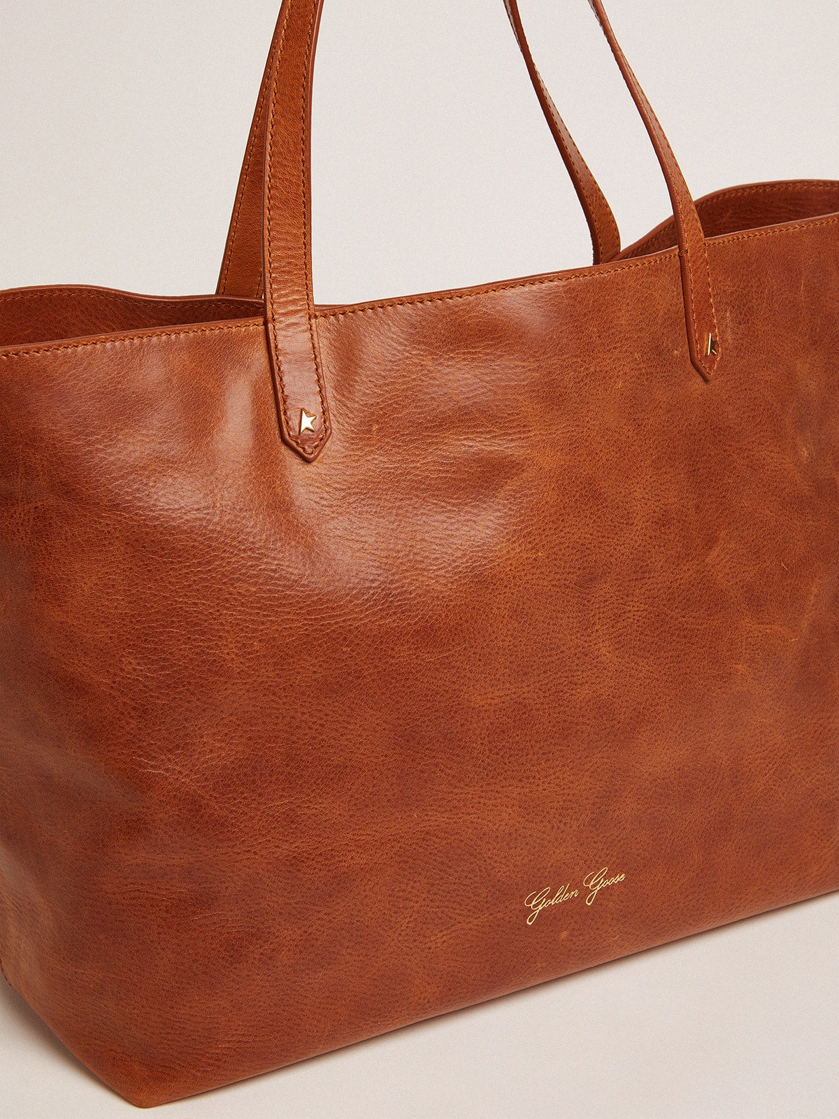 Pasadena Bag in tan-colored glossy hammered leather with gold logo on the front| Golden Goose